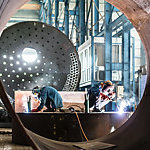 Two workers welding in a factory.