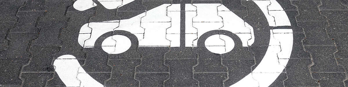 Electric charging station symbol and inscription on a street. The sign direct cars towards an electric charging station.