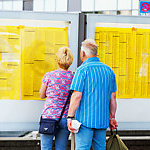 Essen, Germany - June 7, 2014: A caucasian senior couple is standing at timetable for trains. Scene is at main station of Essen. Couple is watching and reading timetable for local trains and S-Bahn. summer shot.